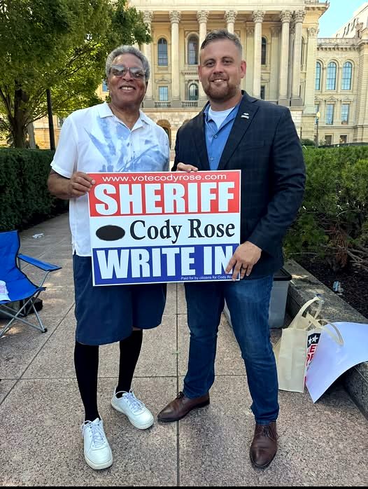 Gary Pierce and Cody Rose outside the Illinois State Capitol, holding a Cody Rose write-in sign for Sheriff.