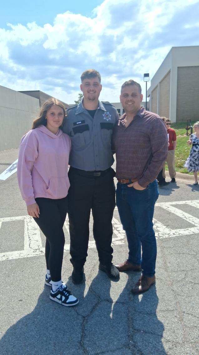 Cody Rose with his son in Correctional Officer uniform at his graduation.