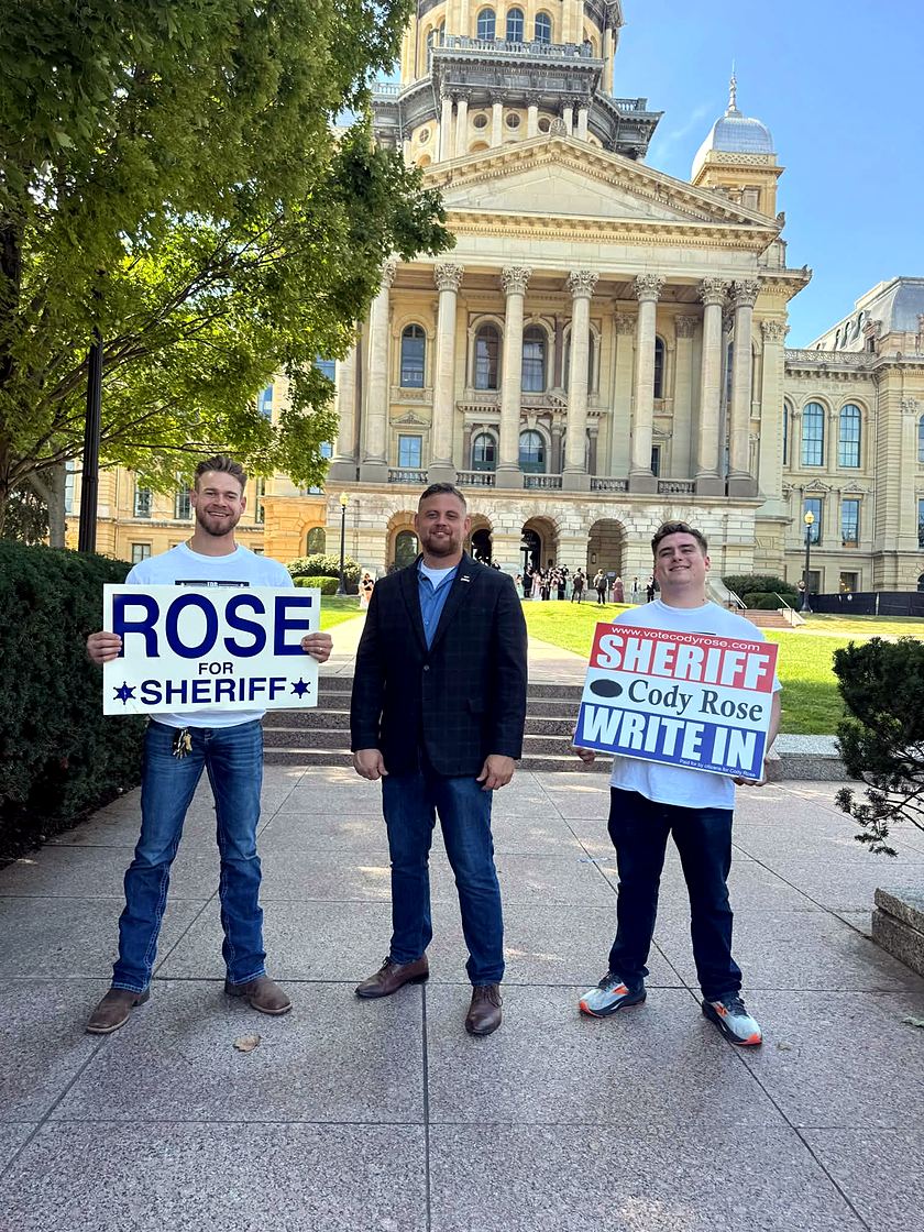 Cody Rose and two supporters outside the Illinois State Capitol in Springfield, holding Rose for Sheriff and Cody Rose write-in signs.