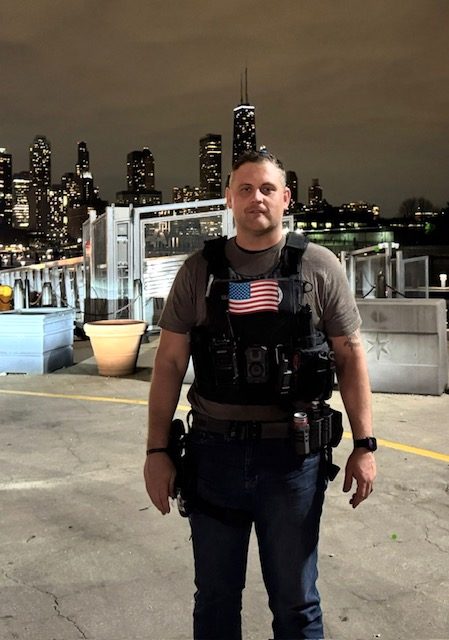 Cody Rose in a plate carrier on assignment in Chicago at night.